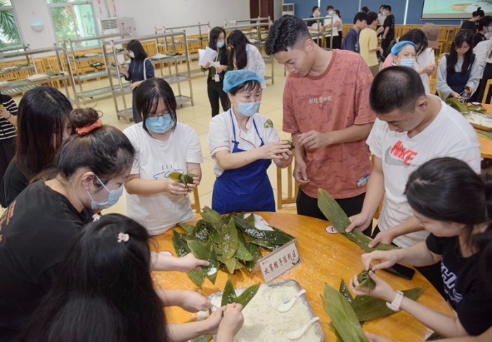 集美大学举行庆端午节包粽子比赛。图为，比赛前，食堂师傅在向参加比赛选手讲解包粽子技巧。（林志杰摄影）-2.jpg