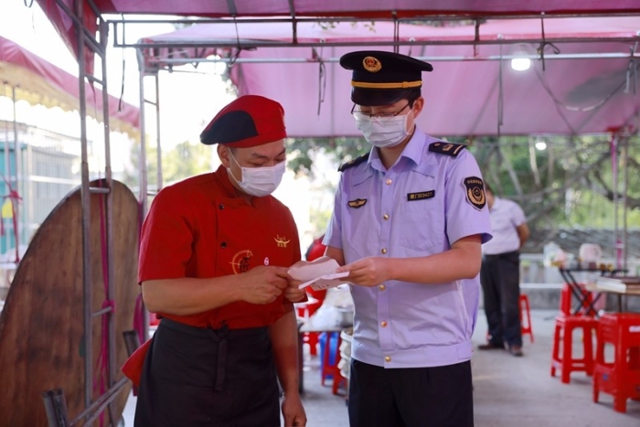 监管人员在乡宴现场查看食品原材料索证索票情况(区市场监管局供图).JPG