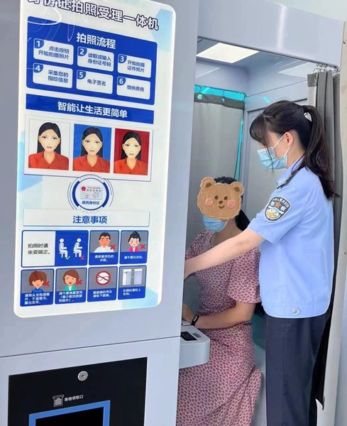 工作人员现场指导市民在机器上办理业务.jpg