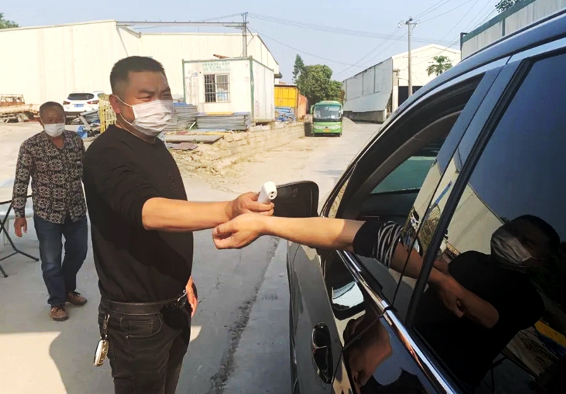 黄孟勤在检查来往人员体温.jpg