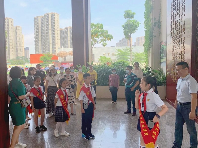 家长们走在三风一训处，聆听解说员对学校教育理念的介绍（厦门外国语集美分校）.jpg